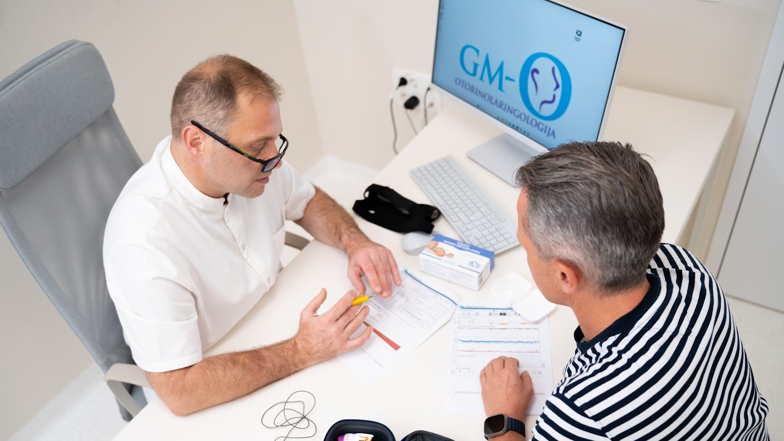 ORL specialist med posvetom razlaga pacientu izvid preiskave